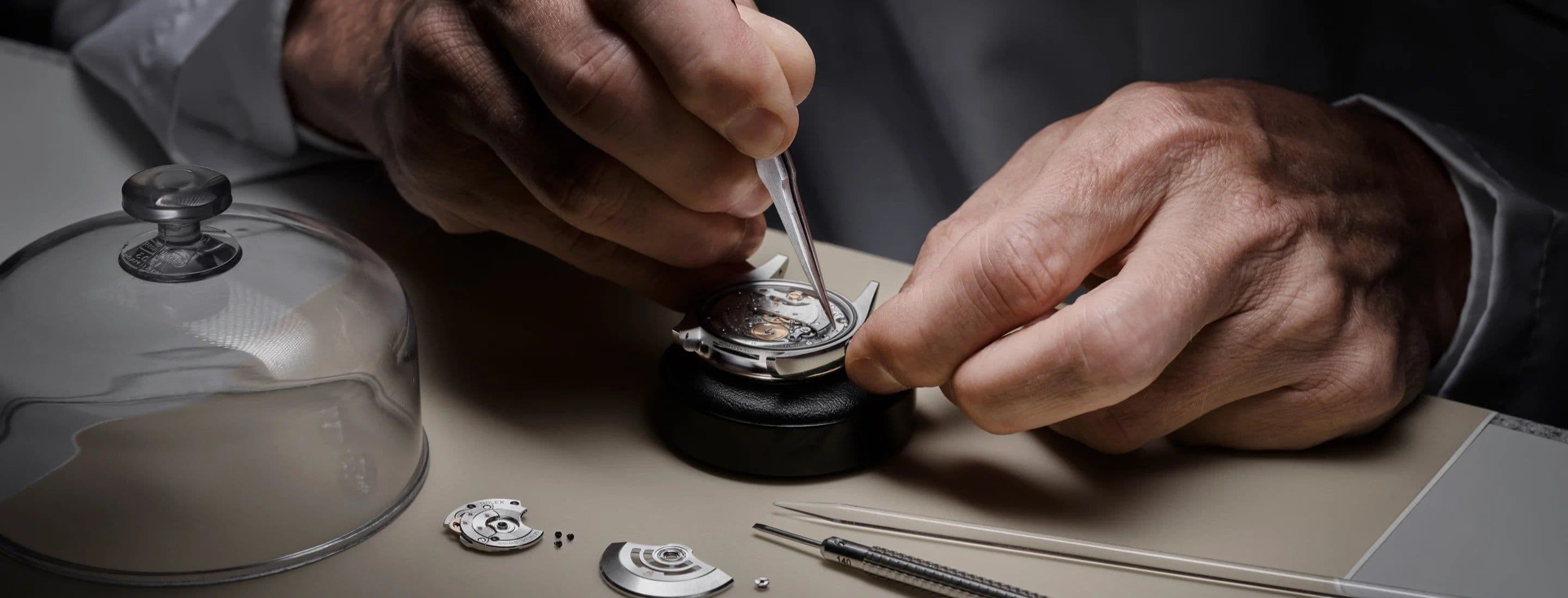 Man performing surgery on a Rolex watches mechanism
